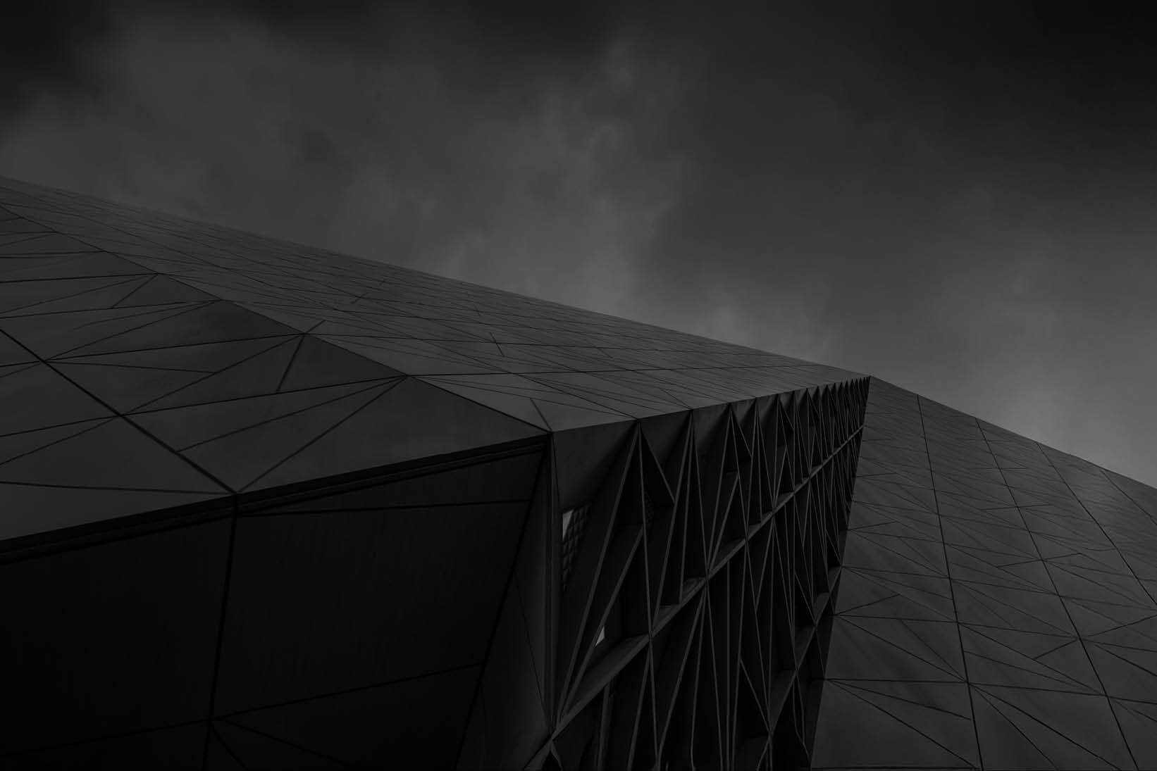 Contemporary geometric building facade viewed from below, representing stability, growth, and long-term value creation - used on Capco Wealth and Asset Management