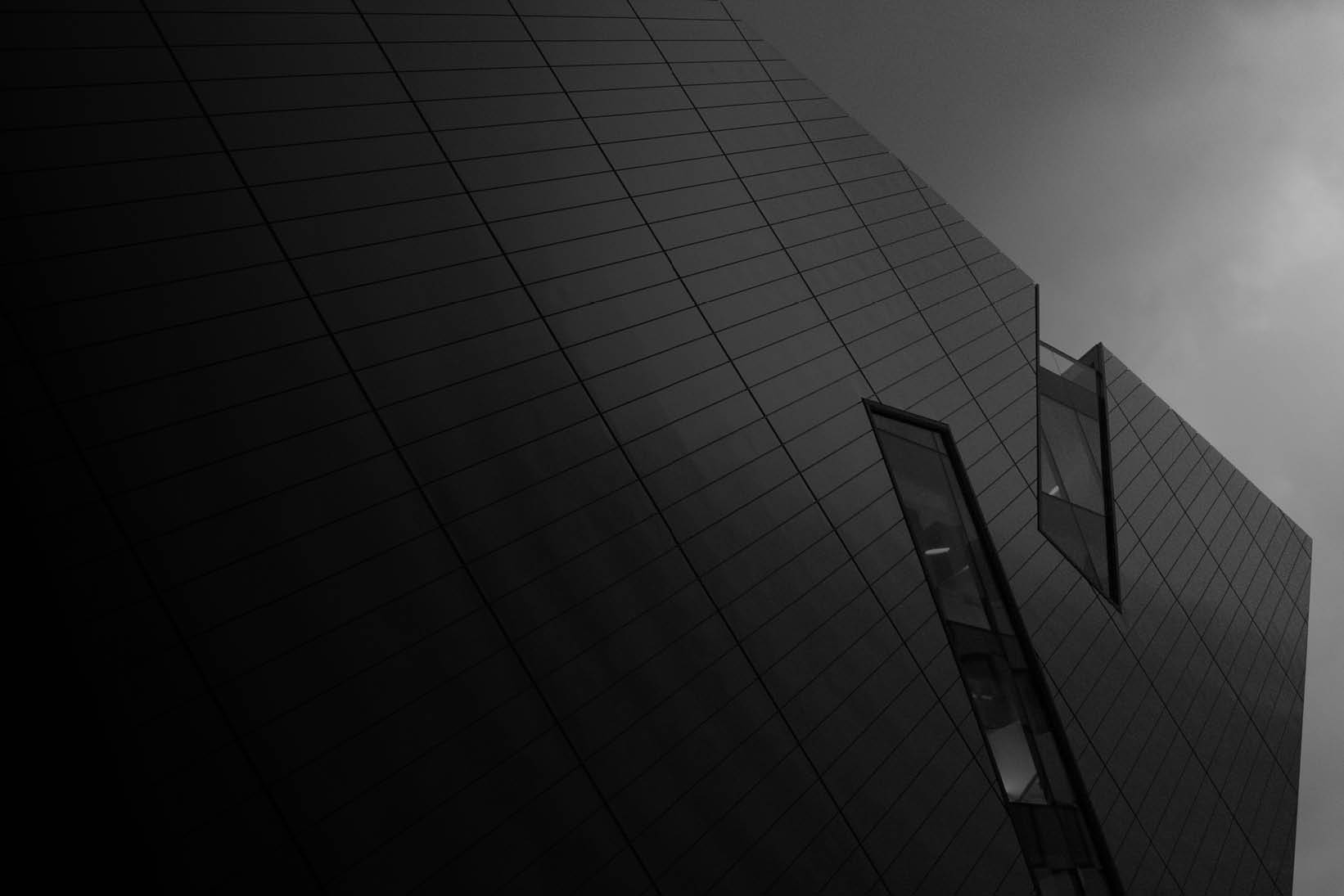 Modern architectural facade with sharp geometric lines and reflective surfaces, representing innovation, security, and the future of banking and payments - used on Capco Banking and Payments