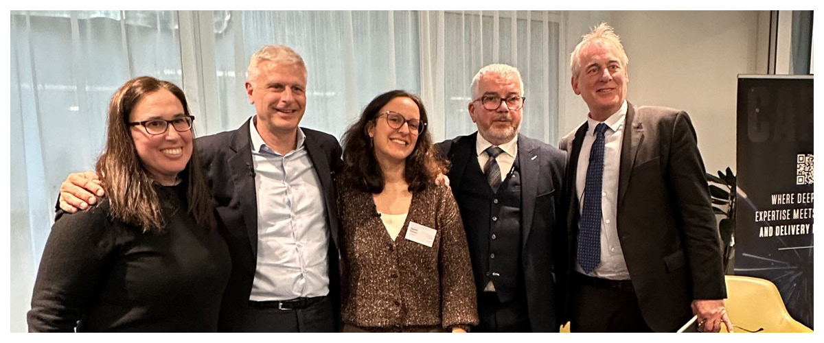 Five professionals posing together at a Capco networking event in a modern conference space